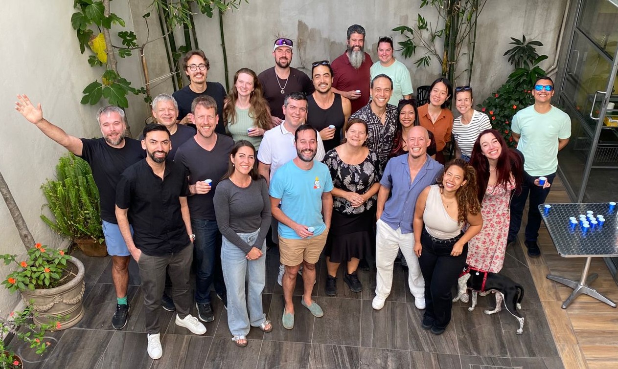 25 business owners smiling in a courtyard after a Build Room build day